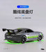 A small, silver Turbo1/76 Miniature RC Remote Control Electric Sports Car by Lacatang Shop, modeled after a Toyota with a rear spoiler and green underglow lights, is shown. The micro RC features detailed black rims and decals on the back. Chinese text is visible in the background.