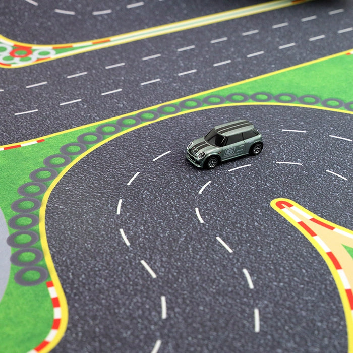 A small toy car zips around Lacatang Shop's Turbo Mini Drift Scene Remote Control Race Car Track, a colorful play mat with curved roads and lane markings in green, red, and gray that excites any young racing enthusiast.