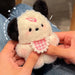 A person holds the Lacatang Shop's Adorable Plush Puppy Keychain, a cute cartoon bag charm for women and girls. This fluffy toy resembles a small white and black dog with a pink checkered bib and blushing cheeks. The background is slightly blurred, and the person wears blue jeans.