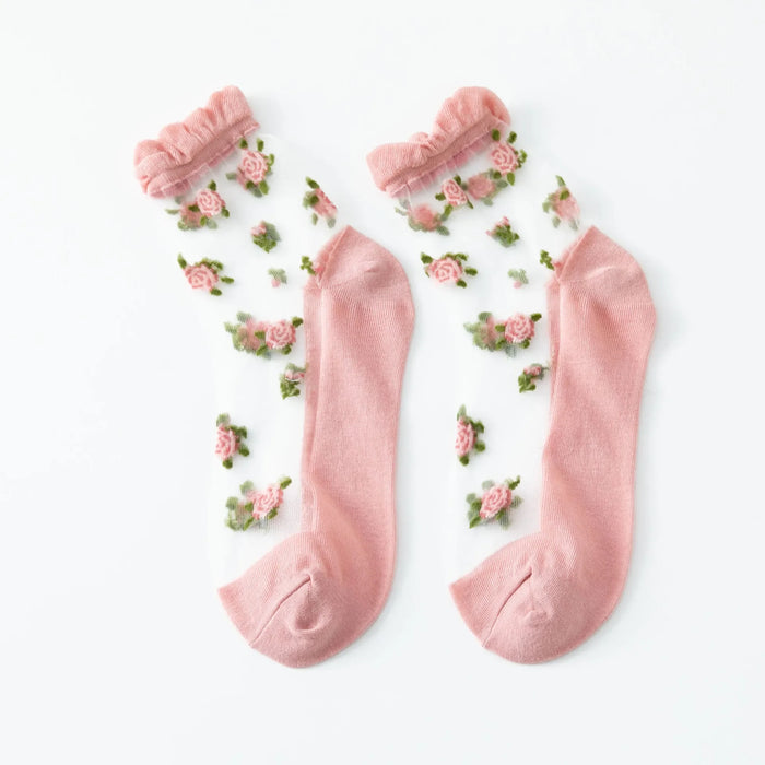 The Lacatang Shop's Delicate Vintage Floral Lace Ruffle Socks feature pink accents at the toes, heels, and cuffs, adorned with a design of pink roses and green leaves for a feminine charm in kawaii Harajuku style.