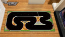 Lacatang Shop's Large 160x90cm Portable Turbo Track Mat for 1:76 RC Mini Cars features a black track with red and white edges, checkered finish line, and "Turbo Racing" logo on a wooden floor amid furniture and TV for the perfect RC racing experience.