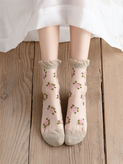 Feet rest on a wooden floor in Lacatang Shop's Delicate Vintage Floral Lace Ruffle Socks, a kawaii Harajuku style with crystal silk and floral embroidery, paired with a white dress for a charming look.