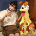 A young person takes a selfie with three yellow Kawaii Oudi Dog Plushies from Lacatang Shop, showcasing their floppy brown ears and big eyes. They sit on a wicker box as the person smiles warmly from a beige sofa, highlighting these perfect room decor toys for anime lovers.