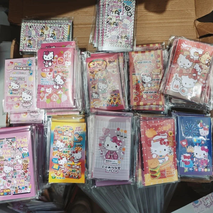 The Lacatang Shop offers kawaii Hello Kitty notepads with diverse designs, neatly displayed on a tabletop in clear plastic packaging and adorned with Kawaii Hello Kitty Sealing Stickers for playful and decorative Sanrio-themed presentation.