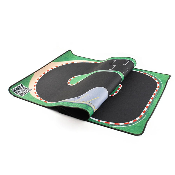 The Lacatang Shop presents the Large 160x90cm Turbo Racing Rubber Track Mat. Designed for 1:76 RC Mini Cars, it features a winding track with green borders and red-and-white checkered edges, lanes, and a small QR code in the corner for an enhanced table racing experience.