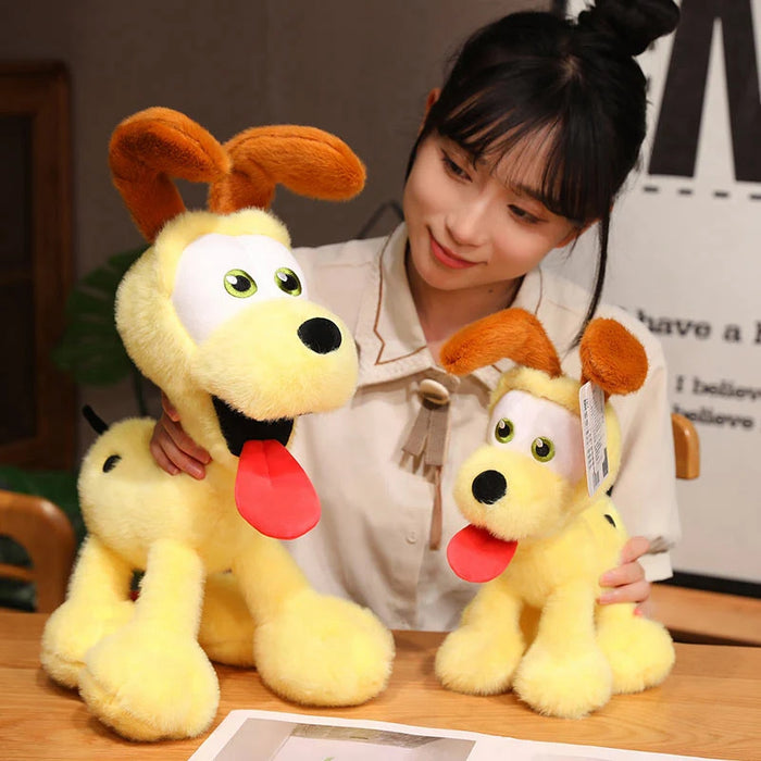 A woman smiles at two Kawaii Oudi Dog plushies from Lacatang Shop, featuring big eyes and floppy brown ears. One is larger, both with red tongues out. These charming toys sit on a wooden table adorned with other decorations.