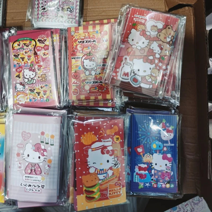 A box displays vibrant Hello Kitty-themed snack packages from Lacatang Shop, showing Sanrio Characters like Hello Kitty with teddy bears or fireworks. Each package, ideal for ages 8+, includes Kawaii Hello Kitty Sealing Stickers for cute anime Sanrio packaging décor.