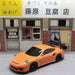 A 2.4G RC Drift Car 1/43 4WD Remote Control Car, by Lacatang Shop, is parked in front of a building with Japanese signage for a handcrafted tofu shop named "藤原豆腐店." The scene vividly represents a traditional Japanese storefront.