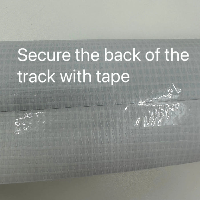 A close-up showing a textured surface with clear tape applied horizontally. Text reads: "Secure the track's back with tape." The neutral, light background is perfect for Lacatang Shop’s 3.2m durable PVC cloth track for RC Mini-Z, Mini-Q, and Wltoys K989 K969 drift cars.