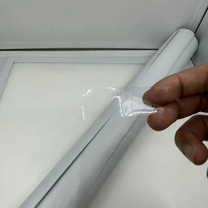 A hand holds a small piece of transparent adhesive tape against a white grid-patterned sheet, suggesting plans for the 3.2m PVC Foldable Racetrack, designed for RC mini cars like Kyosho Mini-Z and WLtoys K989. The scene is set in a well-lit workspace by Lacatang Shop.