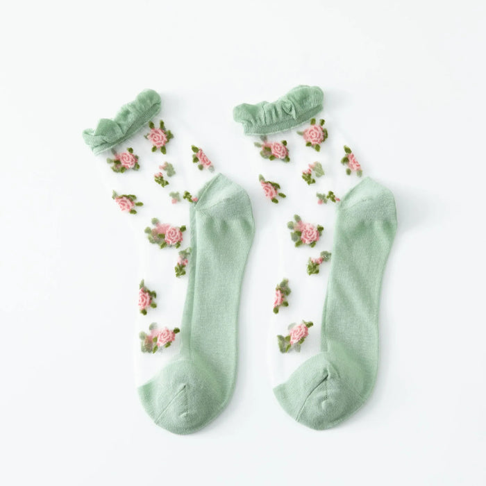 The Lacatang Shop's Delicate Vintage Floral Lace Ruffle Socks feature pastel green toes, heels, and cuffs with pink rose patterns and green leaves on sheer fabric, embodying kawaii Harajuku style.