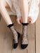 A person in a white dress with orange polka dots sits on a wooden floor, adjusting their Lacatang Shop Ultra-thin Transparent Crystal Silk Crew Socks. These sheer black socks are embroidered with pink roses, capturing the charm of Vintage Floral Lace Ruffle Socks in Kawaii Harajuku style.