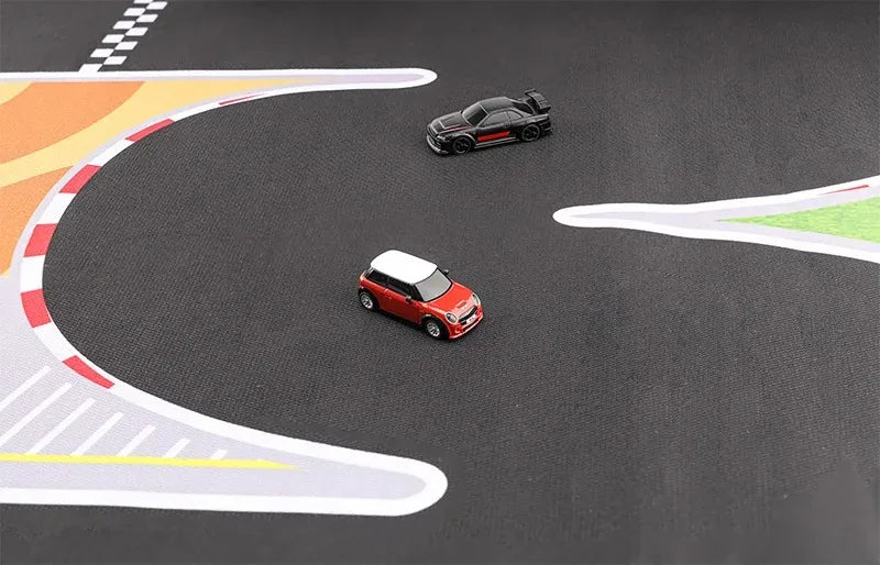 Two miniature cars zoom on Lacatang Shop's Portable Turbo Racing Rubber Mat: a red car with a white roof and a black car with red accents. The 1:76 scale mini RC track features colorful curves, creating an exciting racing scene on its smooth dark surface.