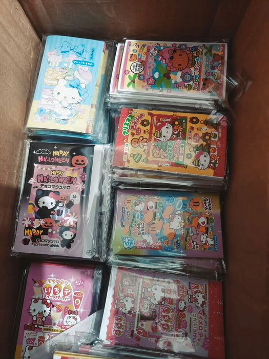 A box of brightly colored packs with cartoon characters, featuring Lacatang Shop's Kawaii Hello Kitty Sealing Stickers. Ideal for themed events or holidays, this cute anime Sanrio packaging is perfect décor for ages 8+.