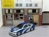 A detailed and sporty 2.4G RC Drift Car from Lacatang Shop, featuring a blue and silver design with a large black spoiler, is positioned in front of a miniature Japanese storefront. The store showcases signs with Japanese text and has a wooden lattice door on the right side. This 1/43 scale high-speed four-wheel drive racing car captures the essence of a real racing vehicle in a compact toy model, making it an exciting gift for boys.