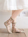 A person in Lacatang Shop's Delicate Vintage Floral Lace Ruffle Socks with Crystal Silk, showcasing kawaii Harajuku style and pink rose embroidery, stands on a wooden floor. These sheer ankle socks have ruffled edges and are beautifully paired with a white skirt.