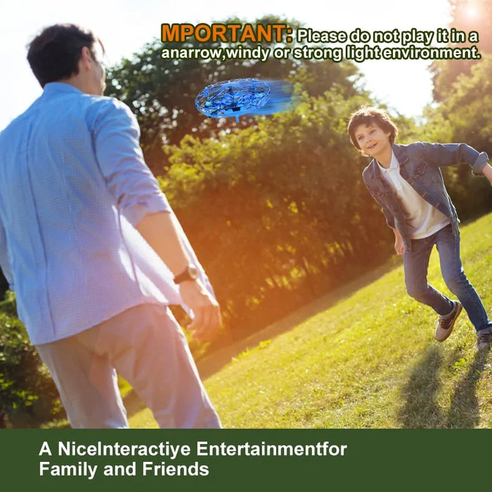 A man and a boy are outside enjoying the Lacatang Shop Quadcopter Drone. The boy is running toward the drone, while the man seems to be keeping an eye on things. At the top, text reads, "IMPORTANT: Please do not play it in a narrow, windy, or strong light environment." Below that, it says, "A Nice Interactive Entertainment for Family and Friends.