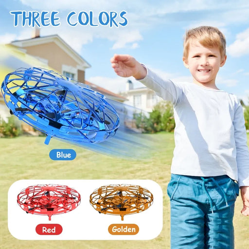 A young boy with light brown hair and a white long-sleeve shirt is outdoors, holding and playing with a small blue Quadcopter Drone. The image, showcasing the Lacatang Shop product, also features the mini helicopter in two other colors: red and golden, with text "THREE COLORS" at the top.